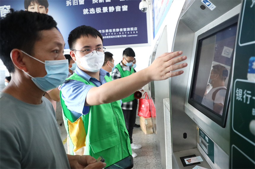 上饒火車站組織青年志愿者引導旅客購票改簽。丁波攝