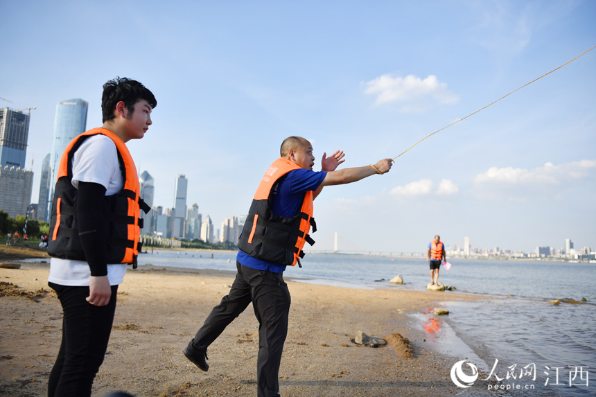 一名老隊員正在教新隊員拋擲救生繩。 人民網 時雨攝