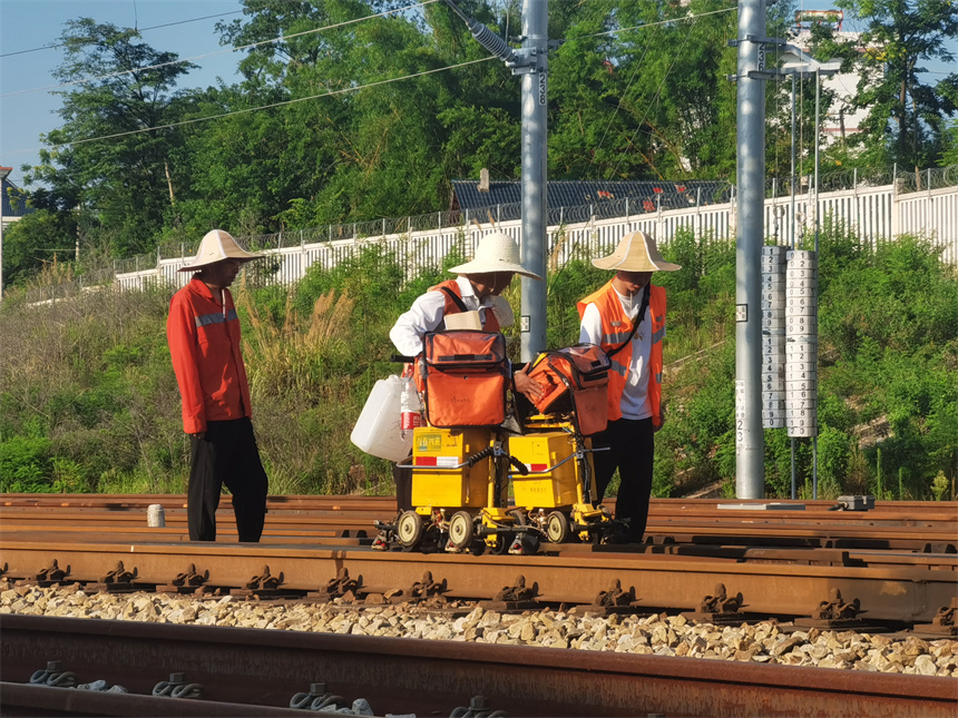 烈日下，鐵路工人正在給鋼軌做探傷檢測。 肖平攝