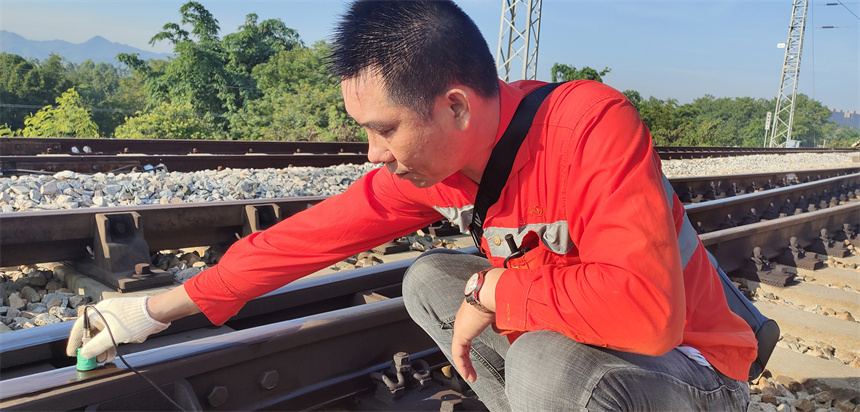烈日下，鐵路工人正在給鋼軌做探傷檢測。 肖平攝