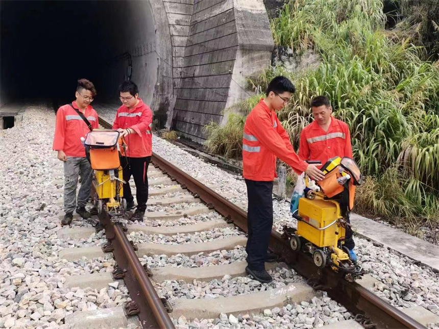 烈日下，鐵路工人正在給鋼軌做探傷檢測。 肖平攝