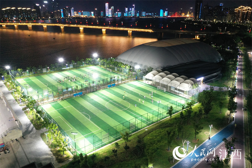 贛江旁的球場上燈火通明，市民正在球場馳騁比拼、揮灑汗水。 人民網 時雨攝