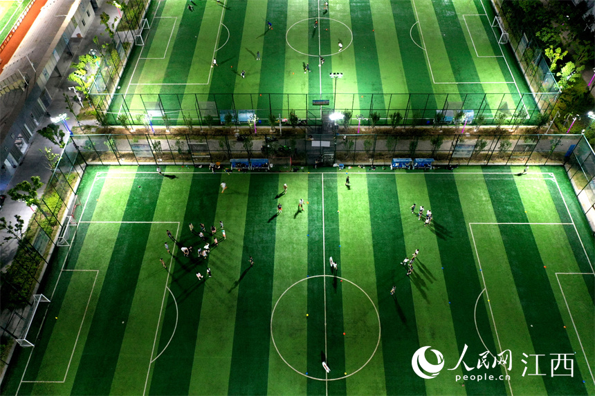 贛江旁的球場上燈火通明，市民正在球場馳騁比拼、揮灑汗水。 人民網 時雨攝