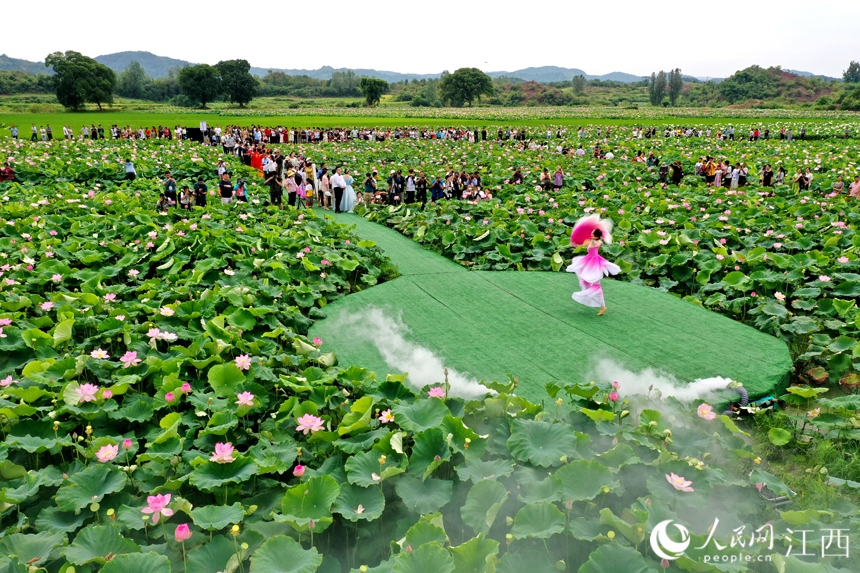 演員正在蓮池的舞臺上演出，吸引著游客們圍觀。 人民網 時雨攝