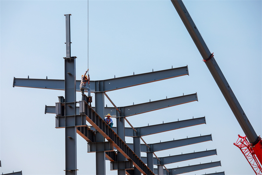 工人們冒著高溫加緊施工。