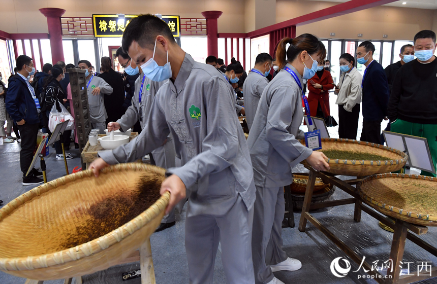 在樟樹岐黃小鎮里，藥工正在進行樟幫中藥炮制技藝展演。 人民網 時雨攝