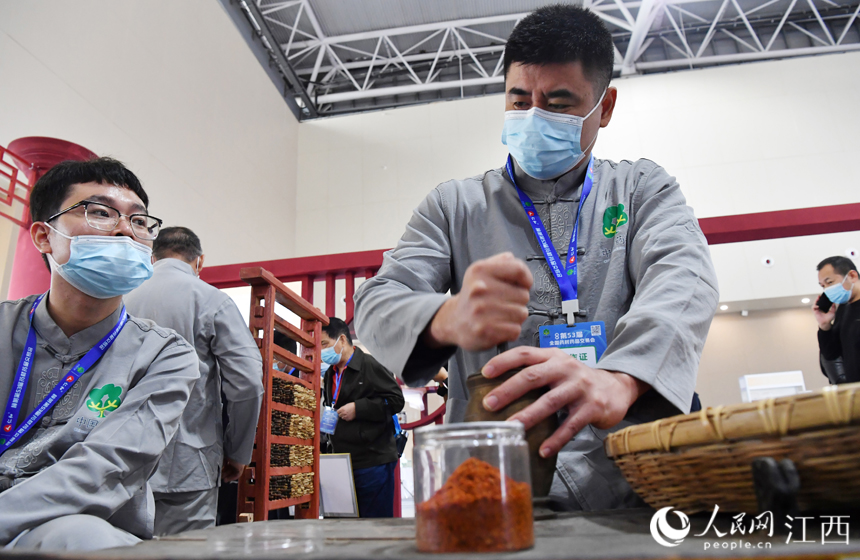 在樟樹岐黃小鎮里，藥工正在進行樟幫中藥炮制技藝展演。 人民網 時雨攝