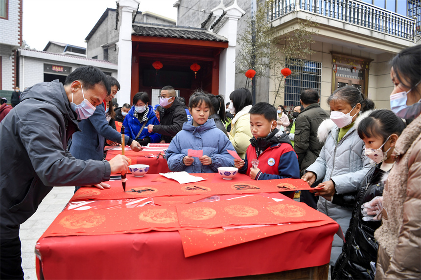 書法愛好者為村民和游客免費寫春聯。周亮攝