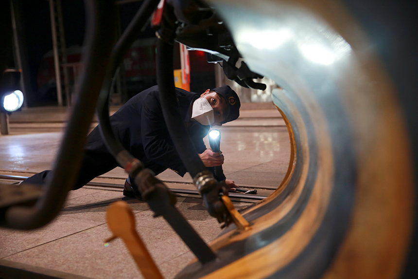 火車司機出發前檢查電力機車車鉤。范俊華攝
