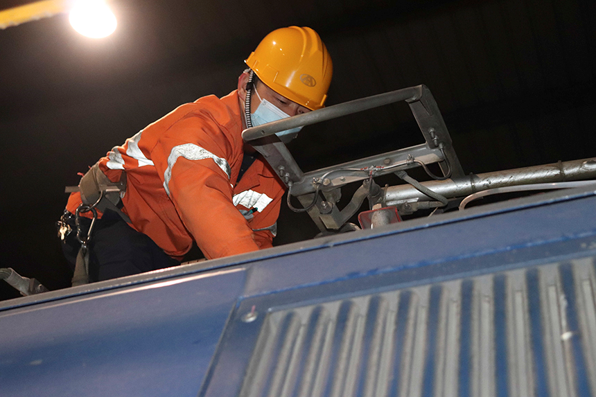 檢修工人正檢查電力機車車頂受電弓。吳木琴攝