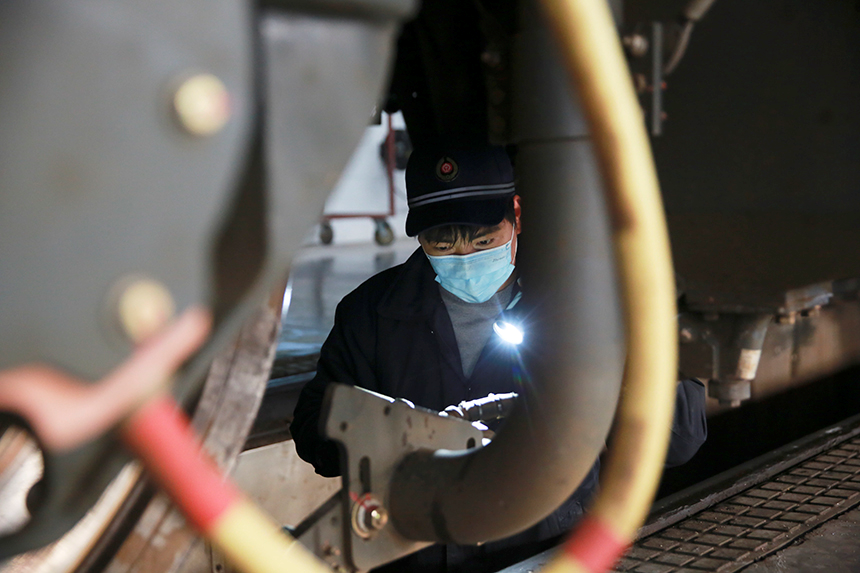 該段青年檢修工人正檢查電力機車砂管。范俊華攝