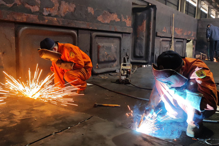 鐵路工人在焊修地板。劉強攝