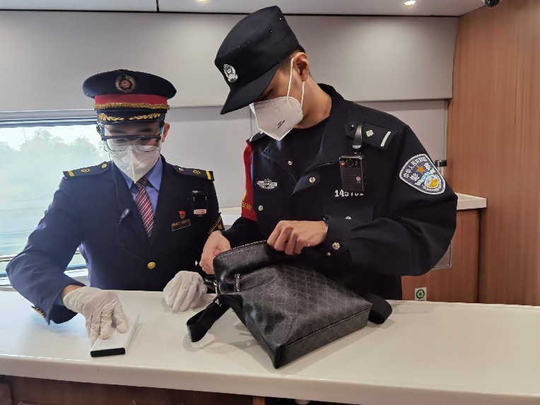 列車長蔣文雄和乘警查看旅客遺失背包。