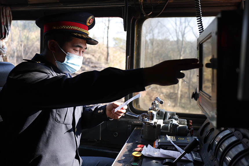 調機司機認真核對調車通知單，確保春耕物資專列運輸安全。劉東攝