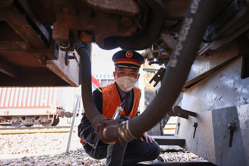 中國鐵路南昌局集團有限公司鷹潭機務段春耕物資專列司機檢查機車風管連接狀態，確保春耕物資專列運輸安全。劉東攝