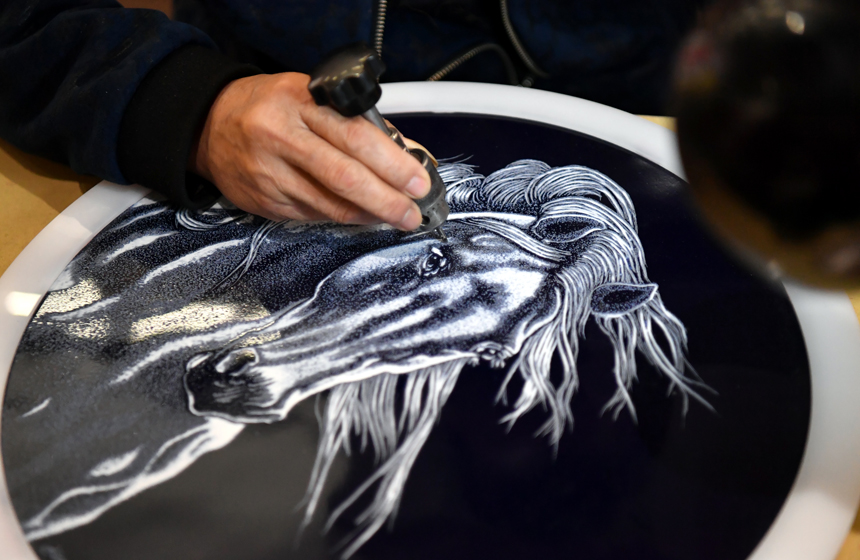 光面瓷盤經過鑿刻后，一匹駿馬展現在眼前。 人民網 時雨攝