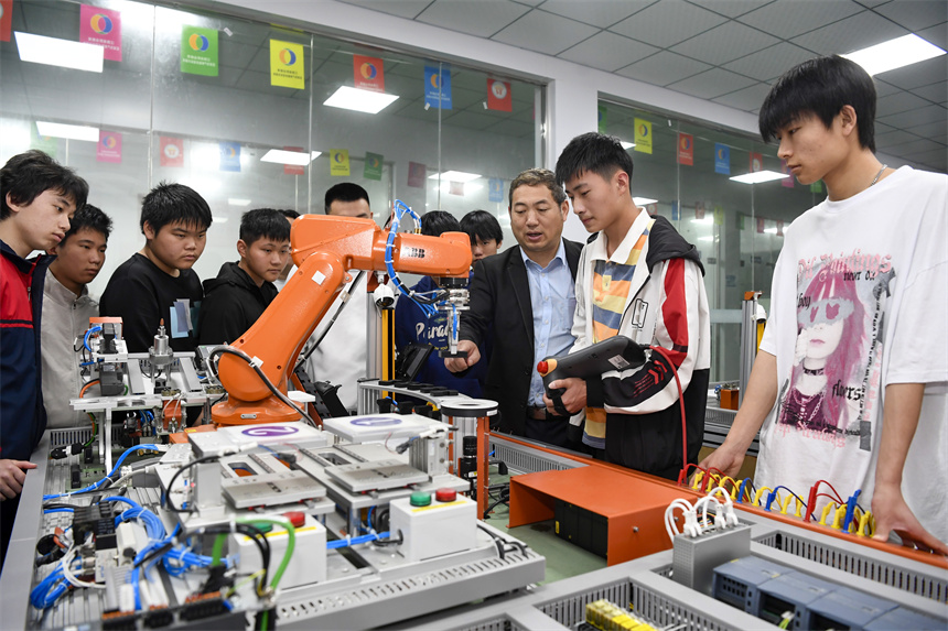 學生在老師的指導下進行工業機器人的操作實訓。周亮攝