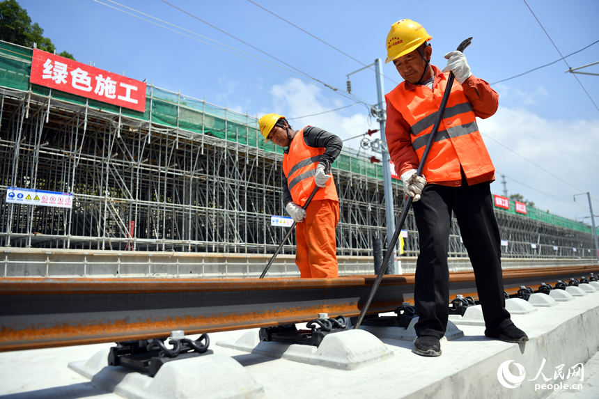 浮梁東站內施工人員正在校正鋪入無砟軌道承軌槽中的鋼軌。 人民網記者 時雨攝