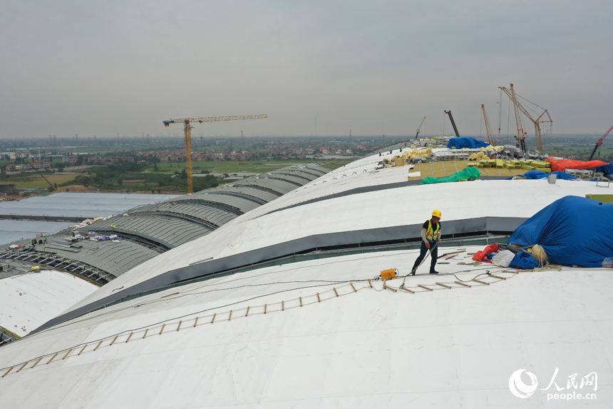工人們正在南昌東站金屬屋面上方施工。 人民網記者 時雨攝