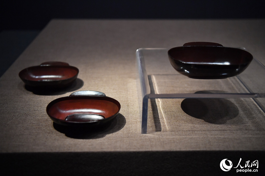 漆耳杯是一種飲食器，耳杯是漢代人常用的飲食器具，因其兩耳形狀類似鳥的雙翼，故又有“羽觴杯”之稱，漢代漆器繼承了楚式傳統，漆耳杯多以紅黑為主色調，是漢人豐富飲食文化的生動例證。人民網記者 時雨攝