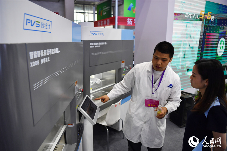展會現場，工作人員正在為觀眾講解并演示“配藥機器人”的工作過程。 人民網記者 時雨攝