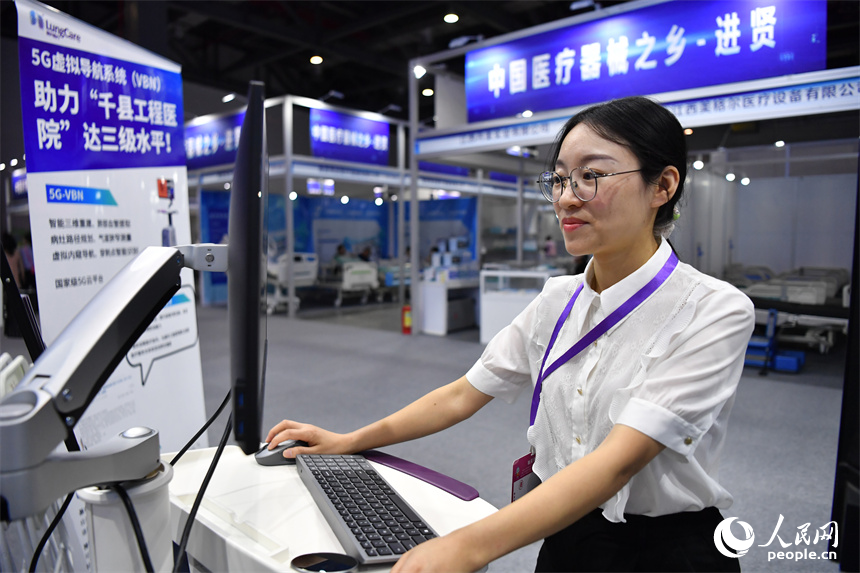展會現場，工作人員正在演示智能醫療設備的工作過程。 人民網記者 時雨攝