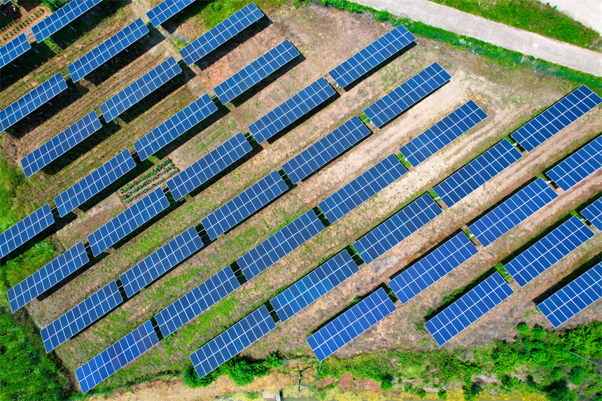 一排排光伏發電板與農居、田園相映成趣，呈現一派鄉村振興的美景。楊鑫攝