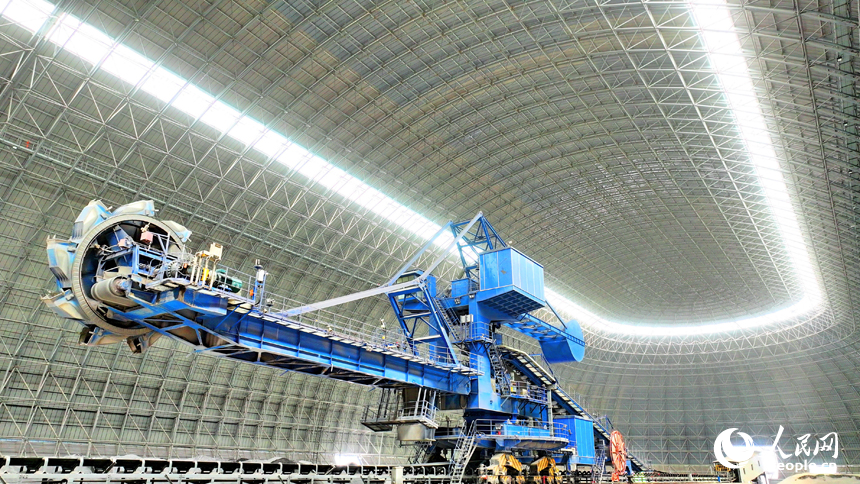 九江市柴桑區的九江港赤湖作業區公用碼頭全封閉智慧“膠囊”倉庫內，大型機械設備在進行取料作業。人民網 朱海鵬攝