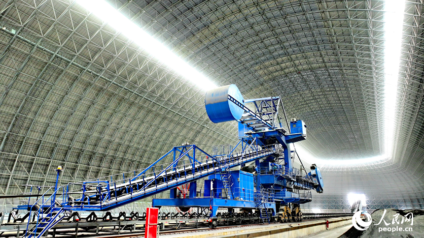 九江市柴桑區的九江港赤湖作業區公用碼頭全封閉智慧“膠囊”倉庫內，大型機械設備在進行取料作業。人民網 朱海鵬攝