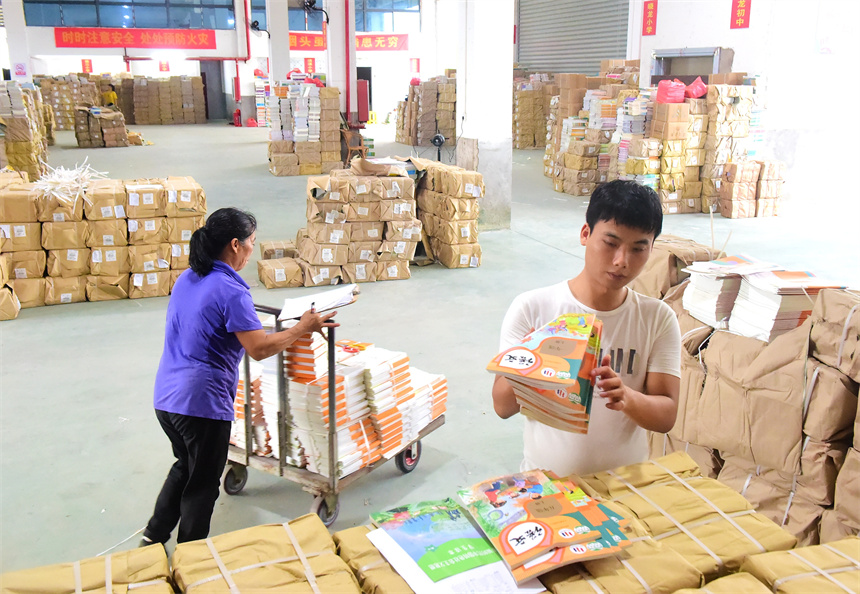 工作人員在課本倉庫內清點、分發2023年秋學期教材和教輔資料。呂春華攝