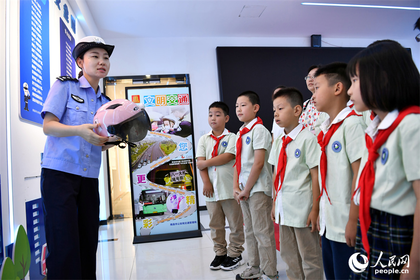 交警正在講解騎行電動車佩戴頭盔的重要性。 人民網記者 時雨攝