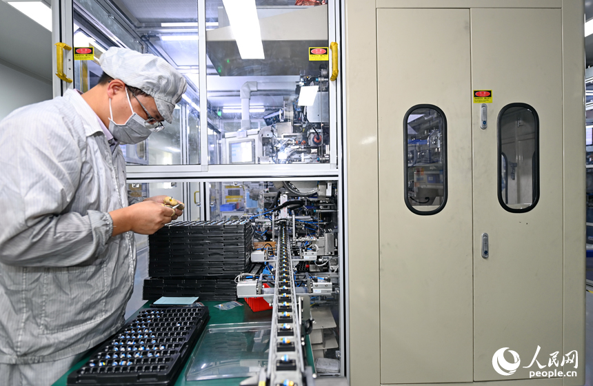 近日，鋰電新能源電池生產企業內，工人在操作電子設備趕制電池產品訂單。人民網 朱海鵬攝
