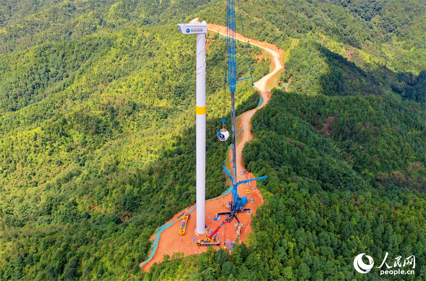在南康區清田風電場二期項目施工現場，工人在吊裝風力發電機組設備。人民網 朱海鵬攝