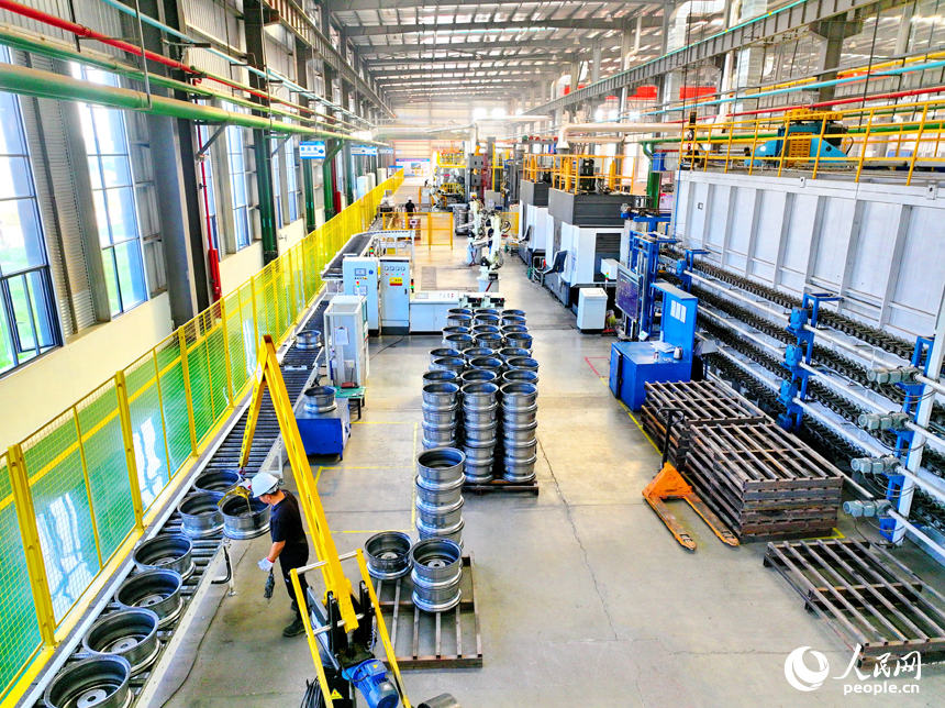 車間內，工人在操作新型智能設備趕制出口輪轂訂單產品。人民網 朱海鵬攝