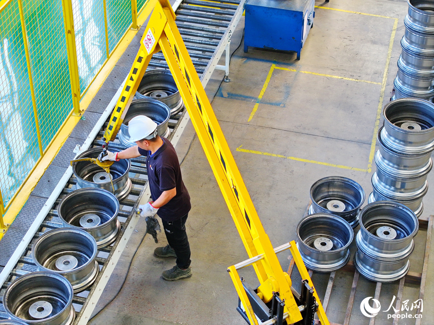 車間內，工人在操作新型智能設備趕制出口輪轂訂單產品。人民網 朱海鵬攝