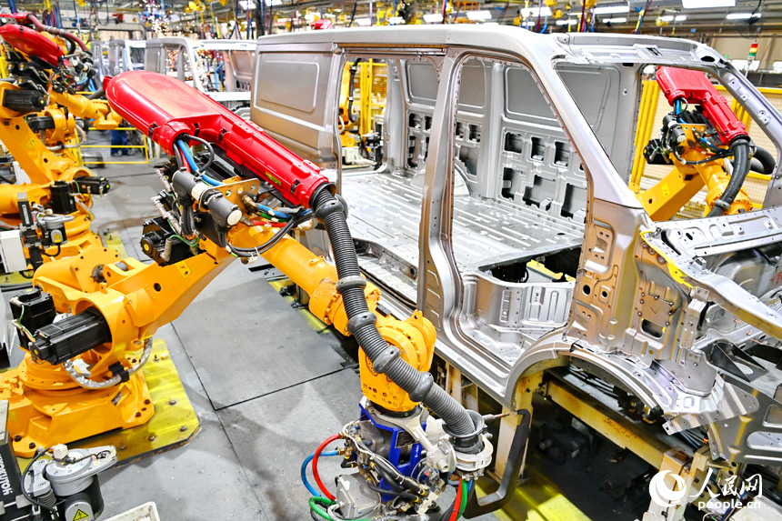 機械手臂在快速運轉，進行微型快遞運輸車車廂自動化焊接。人民網 朱海鵬攝