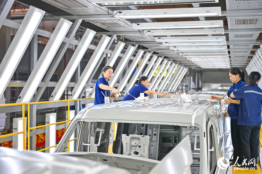 工人在給微型快遞運輸車車廂封膠。人民網 朱海鵬攝