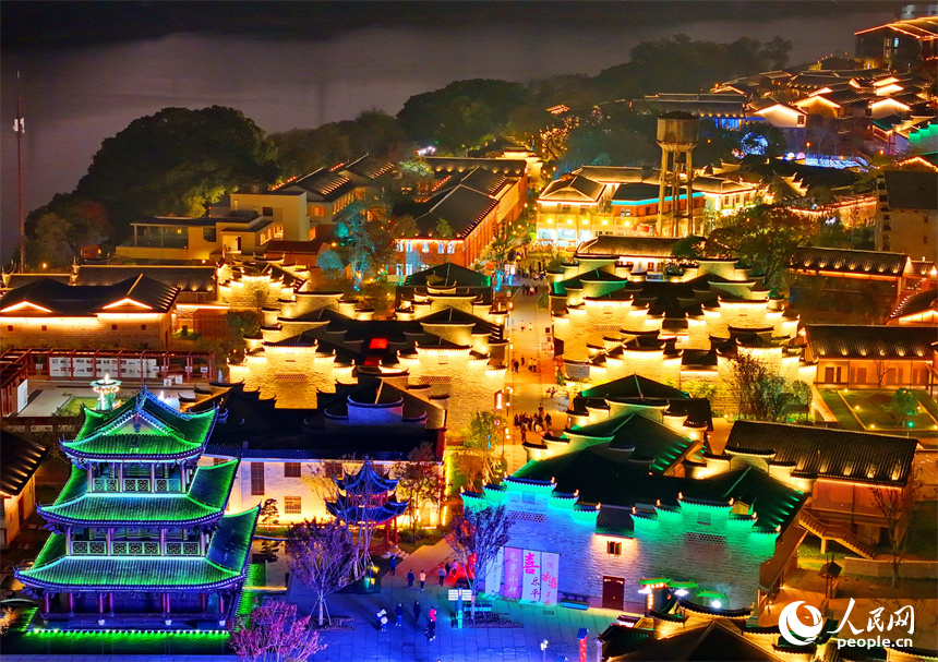 夜色中的七鯉古鎮，與遠處城市高樓大廈相輝映，古色古韻與現代氣息的交融，吸引了許多游客。人民網 朱海鵬攝