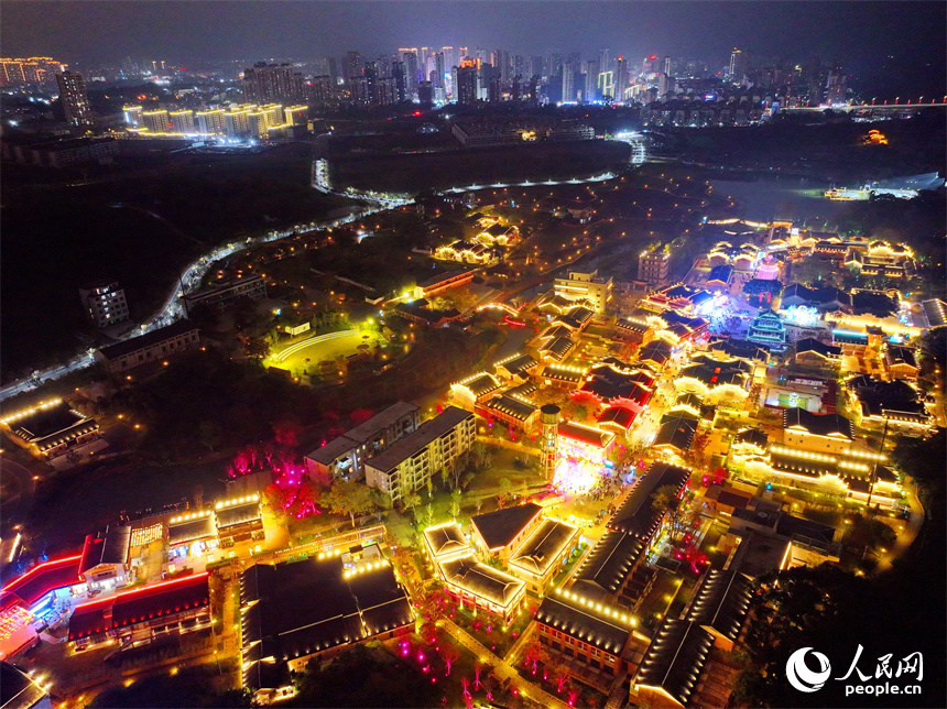 夜色中的七鯉古鎮，與遠處城市高樓大廈相輝映，古色古韻與現代氣息的交融，吸引了許多游客。人民網 朱海鵬攝