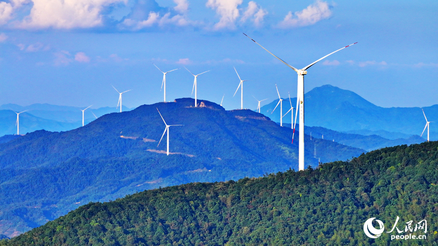 贛州市定南縣歷市鎮群山之上，風力發電機迎風旋轉，轉化為清潔電源并入電網輸往工廠企業、千家萬戶。人民網 朱海鵬攝