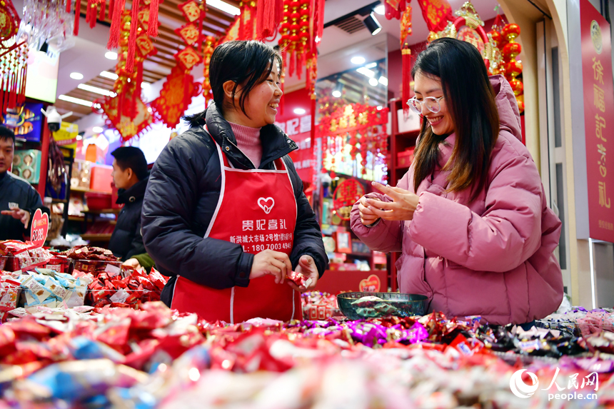 市民正在新洪城大市場的糖果店鋪內選購年貨。 人民網記者 時雨攝