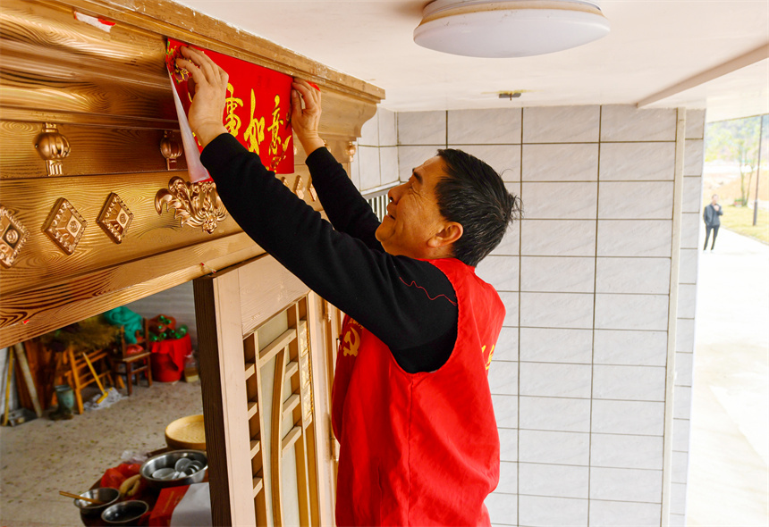 黨員志愿者為村民貼春聯。詹繼成攝 