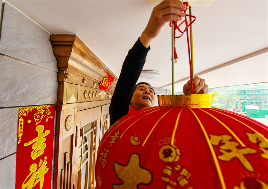 黨員志愿者為村民掛燈籠。詹繼成攝 