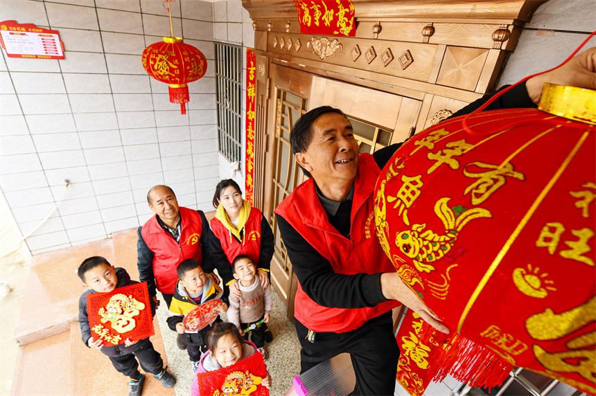 黨員志愿者為村民掛燈籠。詹繼成攝 