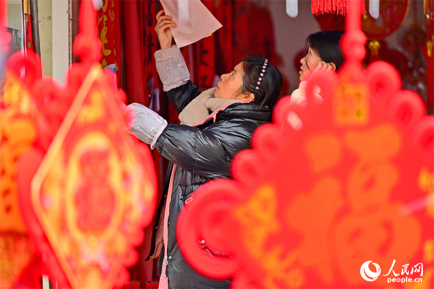 贛州市贛南貿易廣場的喜慶飾品店，市民在選購春聯、燈籠、福字。人民網 朱海鵬攝