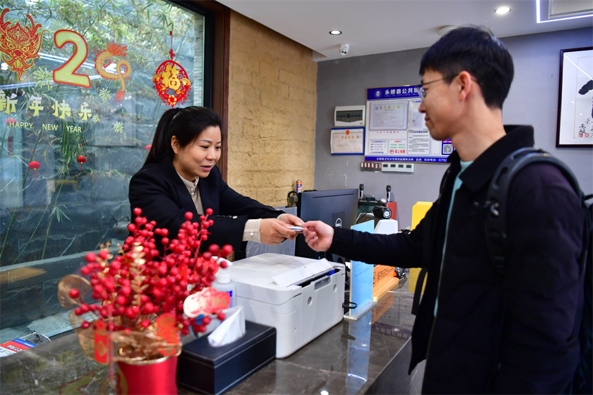 江其花為入住民宿的客人辦理手續。 人民網記者 時雨攝