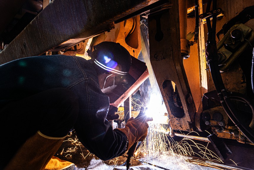 在鷹潭檢修基地檢修庫內工作人員正在對搗固裝置進行電焊作業。邱鋒龍攝
