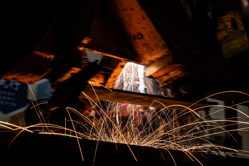 工作人員正在對車輛底部進行電焊作業。邱鋒龍攝