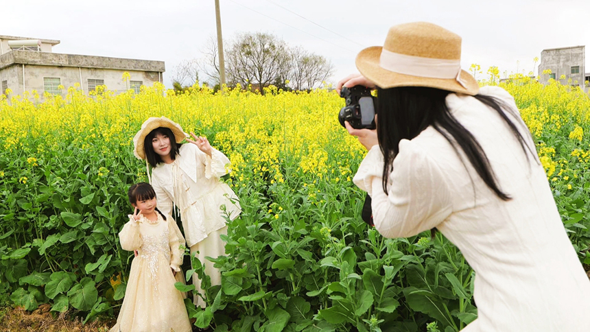 游客在油菜花田中拍照。李禹洪攝