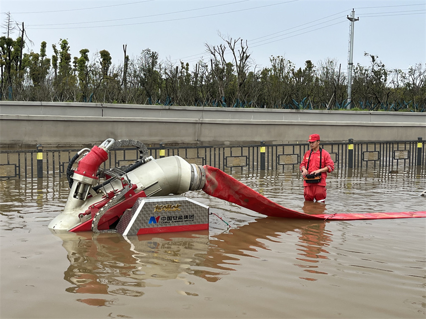 應急救援分隊隊員正使用“龍吸水”排水搶險。 徐迎華攝